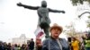 Russia -- An opposition activist holds the Russian Constitution book in front of the monument to Soviet-era opposition legendary bard Vladimir Vysotsky during a protest in the center of Moscow, Russia, Saturday, Aug. 17, 2019